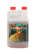 Cannazym 500 ml beyaz şeffaf şişe – turkuaz çerçeveli etiket, altın kök fotoğrafı, iki kırmızı kapak