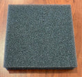 Çimlendirme süngeri levhası – kare gri-siyah gözenekli blok, ahşap zemin üzerinde yandan görünüm